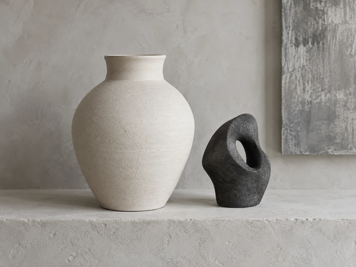 Ceramiczny wazon i rzeźba w kolorze antracytowym na jasnej półce